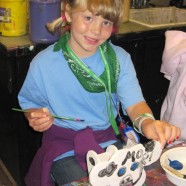 Girl painting cow
